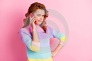 Photo portrait of indifferent girl having boring phone conversation isolated on pastel pink colored background with