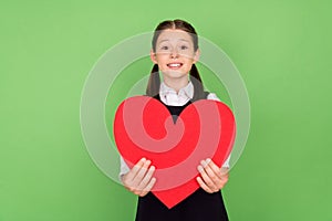 Photo portrait little girl cute cheerful keeping red paper heart postcard isolated pastel green color background