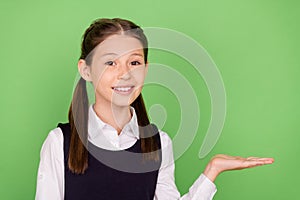 Photo portrait little girl smiling holding blank space on palm isolated pastel green color background