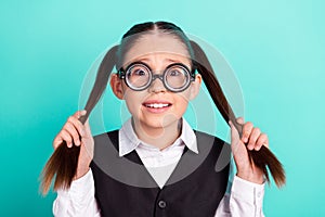 Photo portrait little girl wearing glasses keeping two ponytails isolated pastel turquoise color background