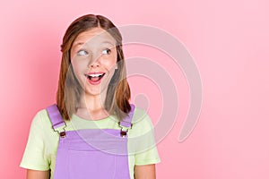 Photo portrait of little surprised girl looking blank space opened mouth isolated on pastel pink color background