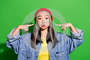 Photo portrait of lovely young lady hold cheeks inflate point fingers dressed stylish denim garment isolated on green