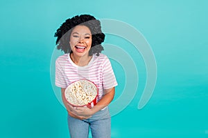 Photo portrait of lovely young lady laugh hold popcorn dressed stylish striped garment isolated on aquamarine color photo