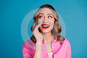 Photo portrait of lovely young lady look empty space share secret dressed stylish pink garment hairdo isolated on blue