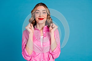 Photo portrait of lovely young lady raise fists winning dressed stylish pink garment hairdo isolated on blue color