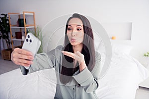 Photo portrait of lovely young lady selfie photo send air kiss wear trendy gray sleepwear isolated on white bedroom