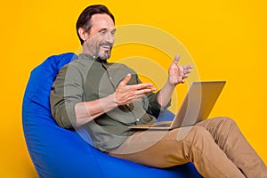 Photo portrait man having meeting on webcamera using laptop isolated vivid yellow color background