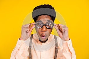 Photo portrait man in shirt wearing spectacles checking eyesight amazed isolated bright yellow color background