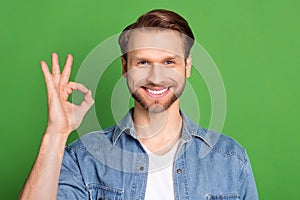 Photo portrait of man showing okay gesture smiling isolated on bright green color background