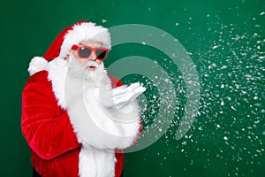 Photo portrait of mature pensioner man blow snowy weather wind dressed stylish santa claus costume coat isolated on
