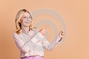 Photo portrait of nice retired female look point empty space wear trendy formalwear isolated on beige color background