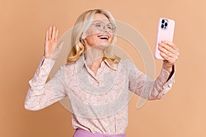 Photo portrait of nice retired female take selfie wave hand wear trendy formalwear  on beige color background