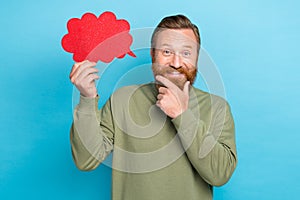 Photo portrait of nice young guy touch beard hold comics dialog thought paper cloud wear khaki garment isolated on cyan