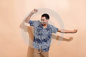 Photo portrait of nice young male dancing have fun disco dressed stylish blue print garment isolated on beige color