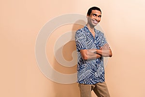 Photo portrait of nice young male folded arms look empty space dressed stylish blue print garment isolated on beige