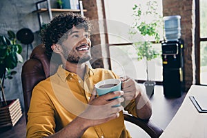 Photo portrait of nice young male wear yellow shirt pause coffee breakfast comfort work table living room interior loft
