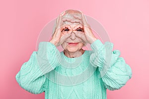 Photo portrait of playful senior lady blonde hair pretending wearing eyeglasses careless funny isolated on pastel pink