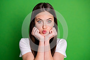 Photo portrait of pouting girl holding face head with two hands isolated on vivid green colored background