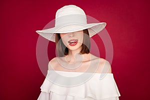 Photo portrait pretty brunette wearing hat covering eyes licking lips isolated red color background