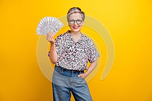 Photo portrait of pretty retired female banknotes money fan wear trendy leopard print outfit isolated on yellow color