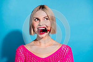 Photo portrait of pretty young girl bite red pomade look empty space wear trendy pink knitted outfit  on blue