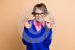 Photo portrait of pretty young girl hands claws hands gesture growl dressed stylish blue outfit isolated on beige color