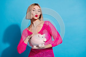 Photo portrait of pretty young girl hold piggy plump lips wear trendy pink knitted outfit  on blue color