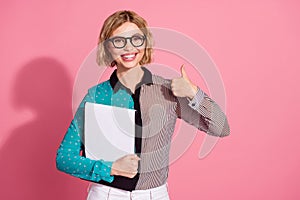 Photo portrait of pretty young girl specs hold document thumb up wear trendy striped cyan outfit isolated on pink color