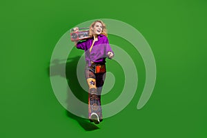Photo portrait of pretty young girl walk look empty space hold boombox wear trendy purple outfit isolated on green color