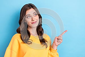 Photo portrait of pretty young woman point look skeptical empty space banner wear trendy yellow clothes isolated on blue