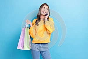Photo portrait of pretty young woman talking phone share shopping sales news dressed stylish yellow look isolated on