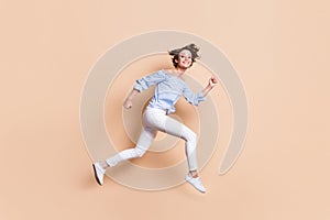 Photo portrait profile of crazy woman running jumping up isolated on pastel beige colored background