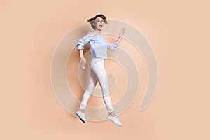 Photo portrait profile of funny girl walking jumping up isolated on pastel beige colored background