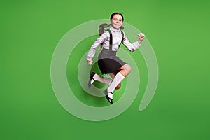 Photo portrait of schoolgirl jumping high up running isolated on vivid green colored background