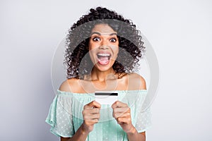 Photo portrait of screaming girl holding credit card in two hands isolated on white colored background