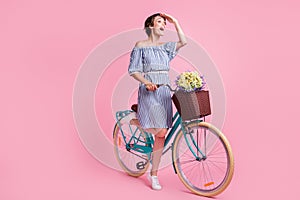 Photo portrait of screaming girl looking in distance standing on one leg holding bicycle with front basket bouquet