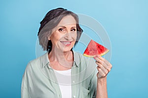 Photo portrait senior woman smiling keeping watermelon in white t-shirt isolated pastel blue color background