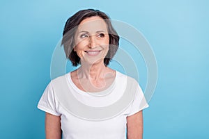 Photo portrait senior woman smiling looking blank space in white t-shirt isolated pastel blue color background