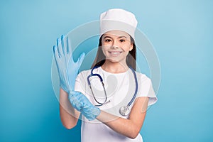 Photo portrait of small nurse with stethoscope put on medical gloves preparing  vibrant blue color background
