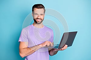 Photo portrait of smiling milennial keeping computer studying browsing internet isolated vibrant blue color background