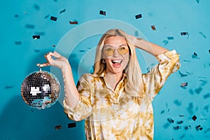 Photo portrait of stunning mature lady hold discoball celebration dressed stylish formalwear clothes  on cyan