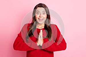 Photo portrait of surprised smiling girl begging asking with keeping both hands together staring isolated on pink color