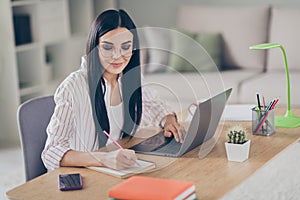 Photo portrait of thoughtful concentrated working from home business woman taking notes with pen in planner doing