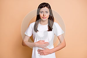 Photo portrait of unwell young woman got bellyache poisoning tummy spasm isolated pastel beige color background