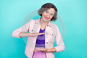 Photo portrait woman in casual clothes showing little size with hands smiling isolated vivid teal color background