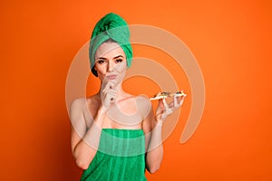 Photo portrait of woman holding pizza slice thinking touching face chin with finger isolated on vivid orange colored