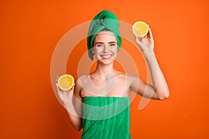 Photo portrait of woman holding two raising one citrus slice over other isolated on vivid orange colored background