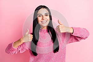 Photo portrait of woman showing two thumbs up isolated on pastel pink colored background