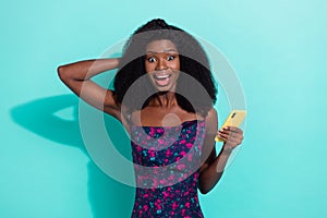 Photo portrait woman smiling surprised staring using app on cellphone isolated on vivid turquoise color background