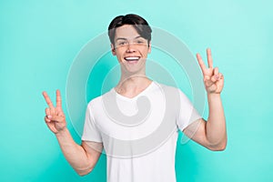 Photo portrait young guy wearing white t-shirt showing v-sign gesture isolated bright teal color background